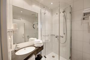 a white bathroom with a shower and a sink at BSW Ferienwohnungen Brockenblick in Schulenberg im Oberharz +57 photos