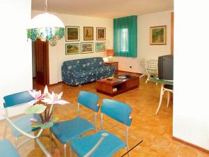 リニャーノ・サッビアドーロにあるLignano Riviera with fireplace & air conditioningのリビングルーム(ソファ、テーブル、椅子付)