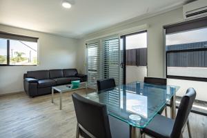 a living room with a glass table and a couch at Hamilton on Beaumont in Newcastle
