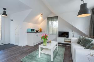 een woonkamer met een witte bank en een tafel bij Apartments Valkenisse in Biggekerke