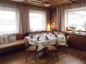 a dining room with a white table and chairs at Haus Rohregger in Mittersill