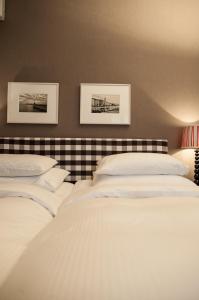 a bedroom with two beds and two pictures on the wall at Hotel Kindli in Zurich