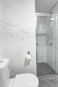 a bathroom with a toilet and a glass shower at Hamilton on Beaumont in Newcastle