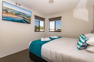 a bedroom with a bed and two windows at Hamilton on Beaumont in Newcastle