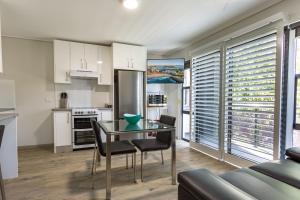 a kitchen and dining room with a glass table and chairs at Hamilton on Beaumont in Newcastle