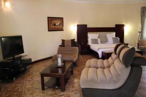 a hotel room with a couch and a bed at Chamba Valley Exotic Hotel in Lusaka