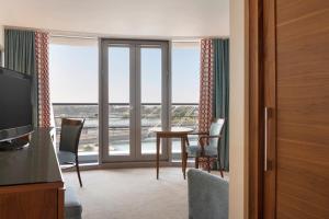 a room with a table and chairs and a large window at Waterfront Southport Hotel in Southport