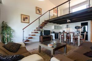 a living room with a staircase and a dining room at Mar da Luz in Luz