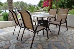 a group of chairs and a table on a patio at Grandes Apartments sea front in Palekastron