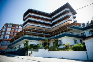 - un bâtiment avec balcon sur le côté d'une rue dans l'établissement Hotel Montañés, à Suances