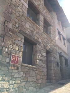 un edificio de piedra con un cartel. en El Pajar del Castillo, en Mora de Rubielos