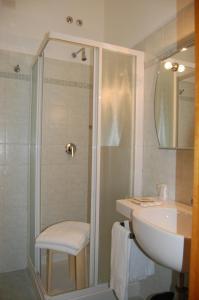 uma casa de banho com um chuveiro, um lavatório e um WC. em Hotel Citta' em Livorno