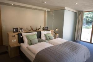 ein Schlafzimmer mit einem großen Bett mit grünen und weißen Kissen in der Unterkunft Landhotel Lammershof in Birkenau