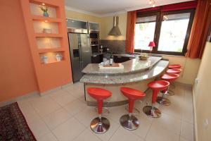 ギア・デ・イソラにあるCasa Marbella Finca SanJuan Batistaの赤いバースツールとキッチンアイランド付きのキッチン