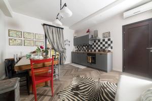 a kitchen and dining room with a table with a zebra rug at Les Petites Maisons in Marta