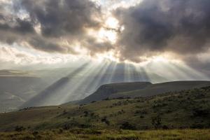 a group of rays of light shining down on a hill at Mount High Luxury Country Estate in Lydenburg