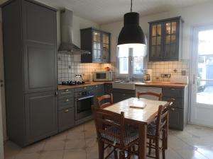 een keuken met een houten tafel met stoelen en een keuken met een fornuis bij Superbe Maison de l'île de Ré in Le Bois-Plage-en-Ré