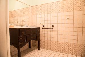 baño con lavabo y pared de azulejos en Hotel Rural El Lagar, en La Solana