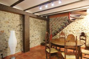 a dining room with a table and a staircase at Can Mariano in Mollet de Perelada