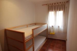 a small room with a bunk bed with a window at Can Mariano in Mollet de Perelada