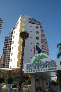 a building with a hotel sign and a palm tree at Riviera Beachotel - Adults Recommended in Benidorm