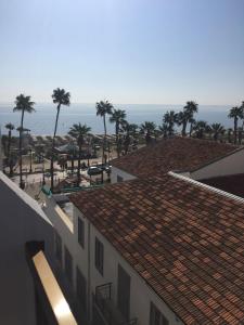 a view of a beach with palm trees and buildings at Nautilus Tourist Apartments in Larnaka