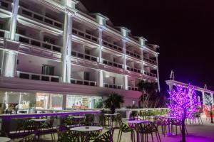 a hotel with tables and chairs at night at Santa Quaranta Premium Resort in Sarandë