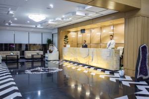 a lobby with two men standing at a reception desk at Santa Quaranta Premium Resort in Sarandë