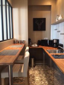 a kitchen with a table and a sink and a counter at Wisteria in Fontainebleau