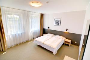 a bedroom with a bed and a large window at Hotel Jurate in Nida