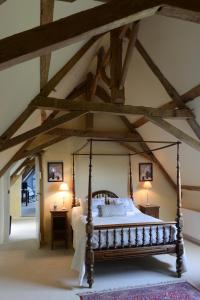 a bedroom with a large bed in a room with beams at Le Manoir de Herouville in Litteau