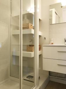 een inloopdouche in een badkamer met witte kasten bij La Rade in Cassis