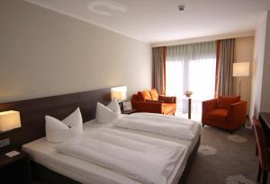 a hotel room with two beds and a living room at Parkhotel Wittekindshof in Dortmund