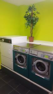 a room with two washing machines and a plant at City Résidence Lyon Marcy in Marcy-lʼÉtoile