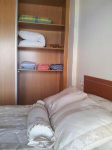 a unmade bed in a room with a closet at Apartamento Piscina Playa Cedeira in Cedeira