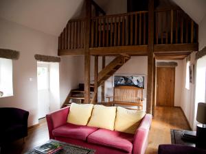 un salon avec un canapé rose et une mezzanine dans l'établissement Kilgraney House, à Bagenalstown