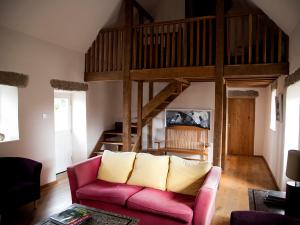a living room with a pink couch and a loft at Kilgraney House in Bagenalstown