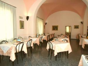 una sala da pranzo con tavoli con tovaglie bianche di Albergo Roma a Casciana Terme