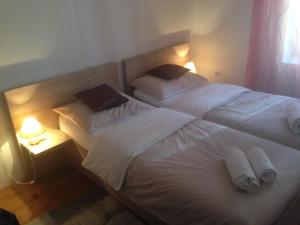 two beds in a bedroom with two lamps and towels at Apartman Roko in Tribunj