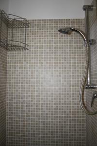 a shower in a bathroom with a tiled wall at Lavanda e Rosmarino Home in Assisi