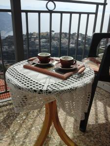 uma mesa com duas chávenas em cima de uma varanda em Appartamento Andrea em Ravello