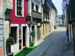 an empty street in a city with buildings at La Posada del Rey in Llanes