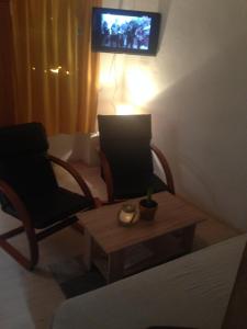 a living room with two chairs and a table and a television at Apartman Roko in Tribunj