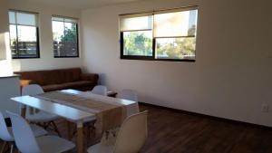 a living room with a table and chairs and windows at Mocaccino in El Pinar