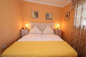 a yellow bedroom with a bed with two lamps at Casa Parlour/UVI in Alcalá