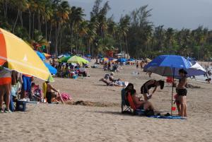 a group of people on a beach with umbrellas at Fajardo Peaceful Place in Playa Sardinera