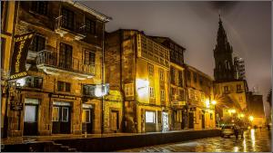 an old city street at night with a church at Oxford Suites Santiago de Compostela in Santiago de Compostela