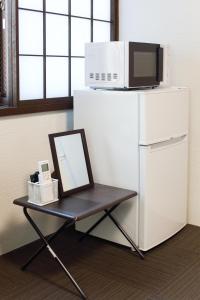 a mirror on a table with a microwave on top of a refrigerator at Kulton Apartment in Kanazawa