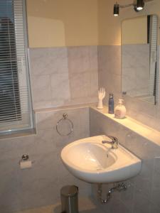 ein Bad mit einem Waschbecken und einem Spiegel in der Unterkunft Ferienwohnung Im Wachturm in Tangermünde