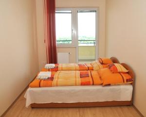 a bed in a room with a window at Tisza Palota Apartmanok in Szeged